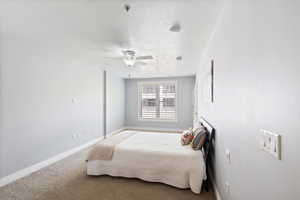 Carpeted bedroom featuring baseboards and a ceiling fan