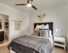 Bedroom with light carpet, a ceiling fan, and ensuite bath