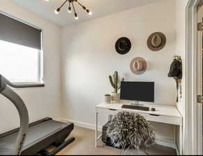 Office with light carpet and a chandelier