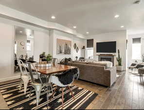 Dining space featuring a fireplace, recessed lighting, and dark wood-style flooring