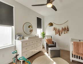 Carpeted bedroom with baseboards and a ceiling fan