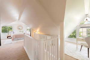 Upper level hallway with lofted ceiling