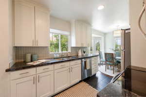 Kitchen with stainless steel appliances, , white cabinets, granite countertops, tile flooring and recessed lighting