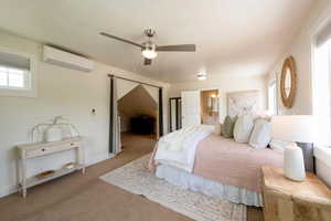 Main suite bedroom featuring  en suite bathroom,  ceiling fan, wall mounted min-split HVAC providing efficient, economical heating and AC.