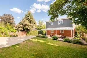 Back of house with  outdoor living space, large patio and lovely Pergola.