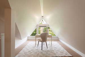 Upper level office with carpet flooring, lofted ceiling