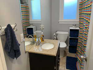 Full bathroom with vanity, tile patterned flooring, and healthy amount of natural light