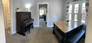 Carpeted dining area with arched walkways and baseboards