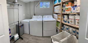 Washroom featuring light wood-style flooring and separate washer and dryer