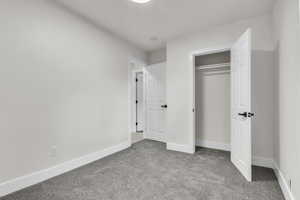 Unfurnished bedroom with carpet and a closet
