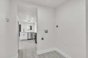 Laundry room with electric dryer hookup, washer hookup, and light wood-style floors