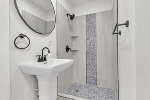 Full bathroom with a tile shower and a sink