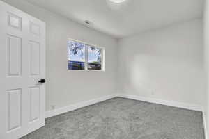 Carpeted empty room featuring baseboards