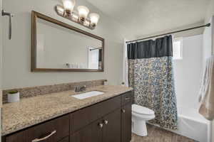 Full bathroom featuring vanity, wood finished floors, and shower / bath combo with shower curtain