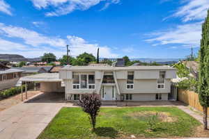 View of front of property with an attached carport, concrete driveway, and a mountain view