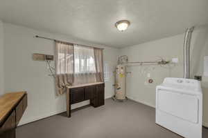 Washroom with washer / clothes dryer, strapped water heater, and a textured ceiling