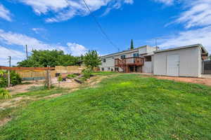 View of yard with a garden, a wooden deck, stairway, and a shed