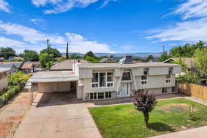 View of front of property featuring an attached carport, concrete driveway, and a mountain view
