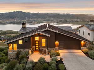 View of front of property featuring stone siding, a mountain view, and a garage