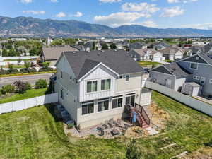 Rear view of house with board and batten siding, a shingled roof, a residential view, and a mountain view