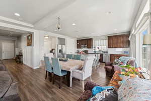 Dining area featuring dark wood-style floors, recessed lighting, and wainscoting