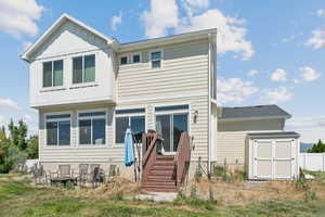 Rear view of property with a storage unit, a fire pit, and board and batten siding