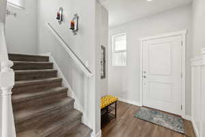 Foyer entrance featuring wood finished floors and stairs