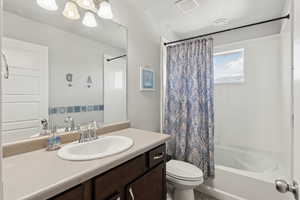 Full bath with shower / bath combo with shower curtain and vanity