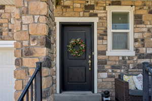 Doorway to property featuring stone siding