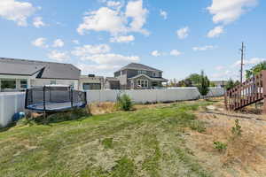 Fenced backyard with a trampoline