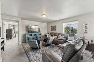 Living room with a textured ceiling and carpet floors
