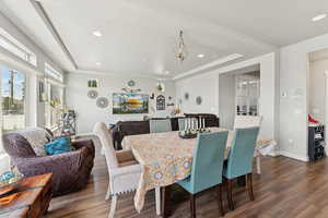 Dining room featuring wood finished floors, a raised ceiling, and recessed lighting