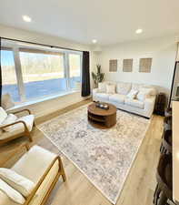 Living room with light wood finished floors and recessed lighting