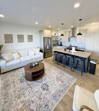Living area with recessed lighting and light wood-type flooring