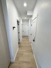 Hallway with baseboards and light wood finished floors