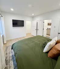 Bedroom featuring light wood-style floors, recessed lighting, and connected bathroom