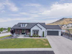 Modern inspired farmhouse featuring a mountain view, a garage, french doors, concrete driveway, and covered porch