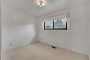 Spare room featuring carpet and baseboards