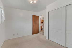 Unfurnished bedroom featuring carpet, a closet, and a chandelier