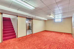 Below grade area featuring carpet and stairs
