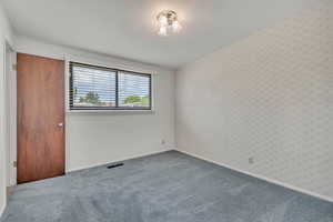 Unfurnished bedroom with carpet floors and baseboards