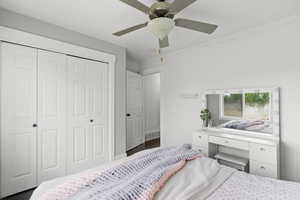 Bedroom with a closet, ceiling fan, and wood finished floors
