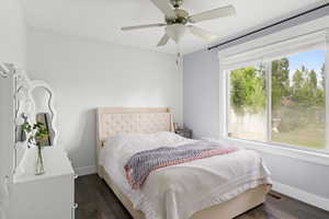 Bedroom with dark wood-style flooring and a ceiling fan