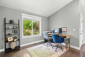 Office space with vaulted ceiling and wood finished floors