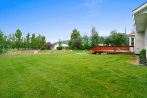 View of green lawn featuring a deck