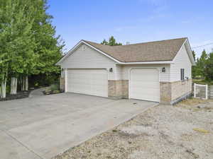 View of front of property featuring brick siding, a shingled roof, and driveway