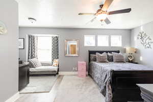 Bedroom with a textured ceiling, wood finished floors, and a ceiling fan