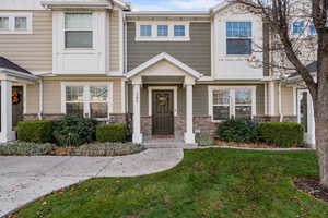View of front of property with a front lawn and stone siding