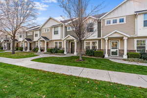 Craftsman-style home featuring board and batten siding, a residential view, stone siding, and a front lawn