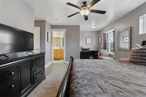 Bedroom featuring light wood-style floors, a ceiling fan, a textured ceiling, and connected bathroom